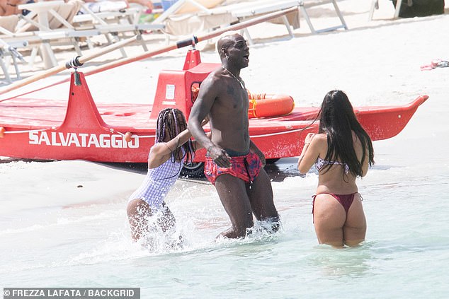 Mario Balotelli splashes in the surf with playful daughter Pia, 9, and a bikini-clad beauty as enigmatic Italian footballer unwinds during pre-season break in Sardinia